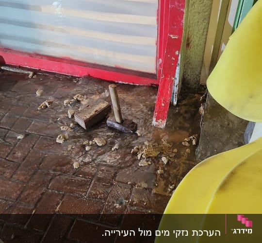 כלים על רצפה רטובה ליד דלת אדומה